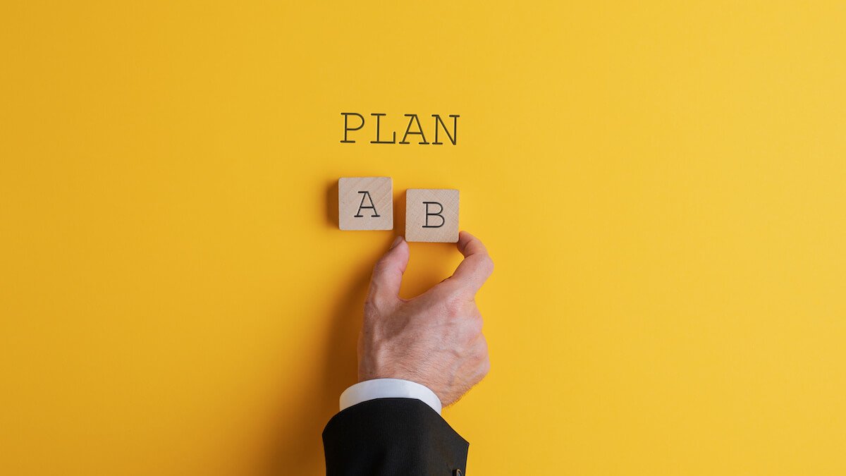 Wooden blocks labeled A and B beneath the word PLAN on a yellow background